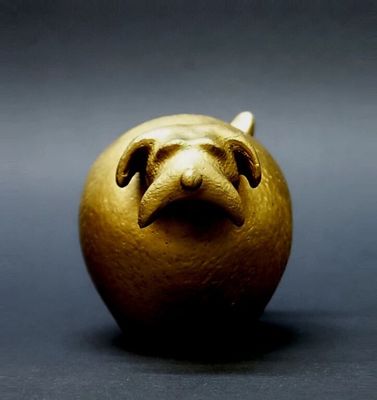 a gold figurine of a dog on a black background