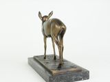 a bronze statue of a deer on a marble base