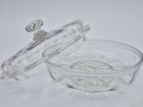 a clear glass bowl with a lid on a white surface