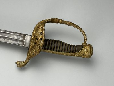 l'image d'une épée à la poignée dorée sur une surface blanche