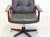 a black leather office chair with a wooden armrest