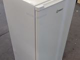 an image of a small white refrigerator in a warehouse