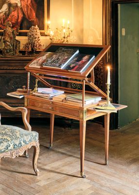 une chaise et un bureau dans une pièce où est accroché un tableau au mur