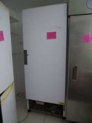 a refrigerator in the corner of a kitchen with a pink sticker on it