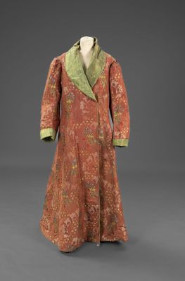 un manteau orange et vert avec un col vert sur un mannequin