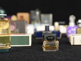 several bottles of perfume are lined up on a black surface