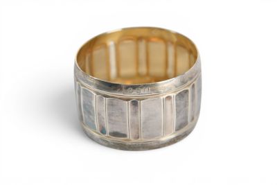 une image montrant un gros plan d'une bague en argent posée sur une surface blanche
