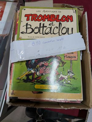 une boîte de bandes dessinées posée sur une table à côté d'une paire de chaussures