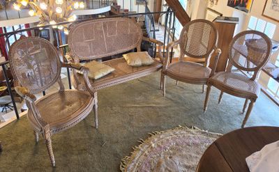 several chairs and a couch in a room with a chandelier in the background
