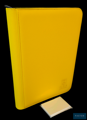 a yellow binder sitting next to a small white piece of paper
