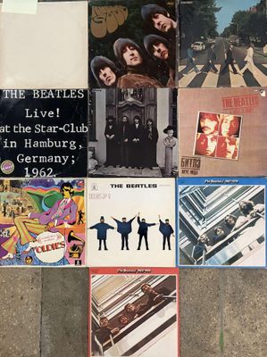 a lot of beatles album covers on the floor