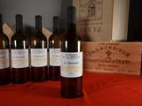 several bottles of wine are lined up on a red table cloth