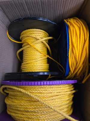 une boîte contenant une corde jaune et une bobine violette