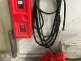 a red fire hydrant next to a yellow fire hydrant in a garage