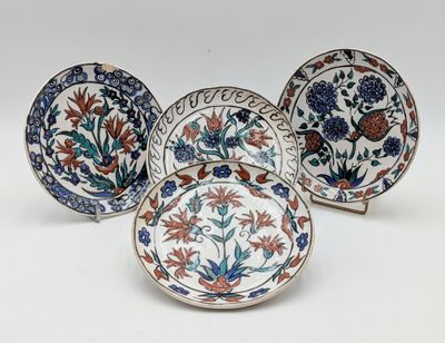 three plates with floral designs on them sitting on a white surface
