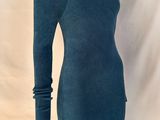Le mannequin porte une robe bleue à manches longues.