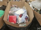 plusieurs sacs de vêtements dans un carton posé par terre
