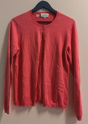 un pull rouge suspendu à un cintre contre un mur