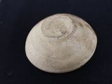 a close up of a white bowl on a black surface