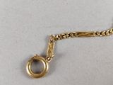 a close up of a gold chain with a ring on it
