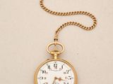 an old pocket watch with a chain hanging from it ' s side