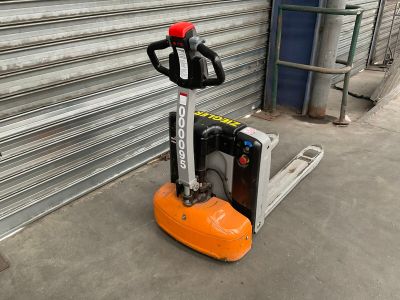a forklift that is sitting in front of a garage door