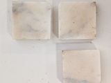 three pieces of soap sitting on top of a white surface
