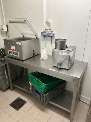 une cuisine équipée d'un évier et d'un plan de travail sur lequel est posé un saladier