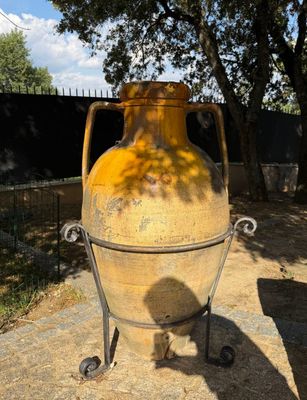 a large yellow vase that is sitting on a stand