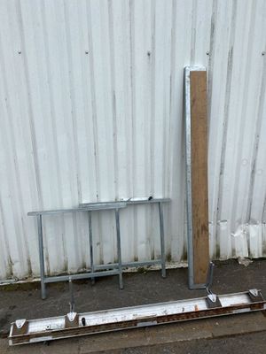 a metal table and a metal bench in front of a white wall