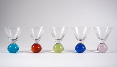 quatre verres à vin de couleurs différentes sont alignés en rangée