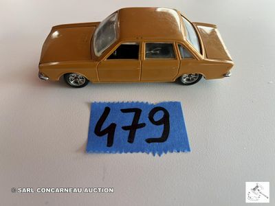 une petite voiture posée à côté d'une feuille de papier bleue