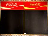 deux affiches Coca-Cola accrochées au mur d'une pièce
