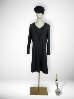 the mannequin is next to a black dress on a mannequin stand