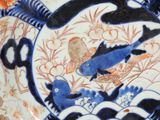 a blue and white plate with a bird and fish on it