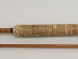 two wooden knitting needles hanging on a wall next to a thread spool