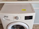 a washing machine sitting in a kitchen next to a stove