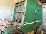 une grosse machine verte garée dans une grange