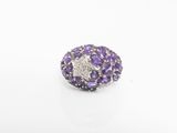 un gros plan d'une bague en diamant violette et blanche