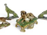 three figurines of dogs and a cat on a table