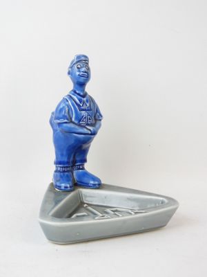 a blue figurine of a man on a surfboard