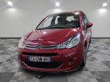 La Citroën rouge est garée sur un sol en damier dans un garage