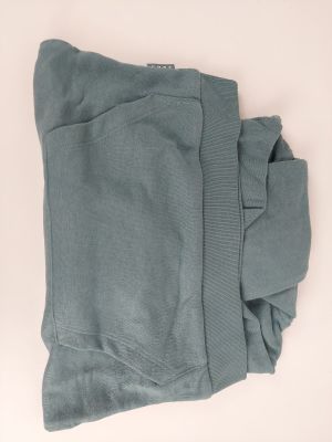 un gros plan sur un pantalon de survêtement bleu posé sur une surface blanche