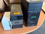 trois ordinateurs posés sur une table dans une pièce