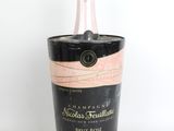 une image représentant une bouteille de champagne dans un seau à glace noir et rose