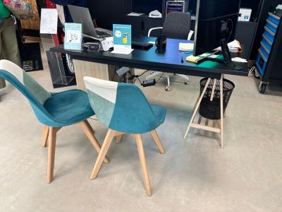 un bureau avec deux chaises et un ordinateur portable dessus