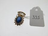 un gros plan d'une bague en pierre bleue et diamants sur une étiquette