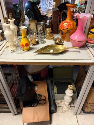une table sur laquelle sont posés de nombreux vases et autres objets