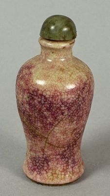 a small vase with a green lid sitting on a table