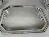 a silver tray with a handle on a table